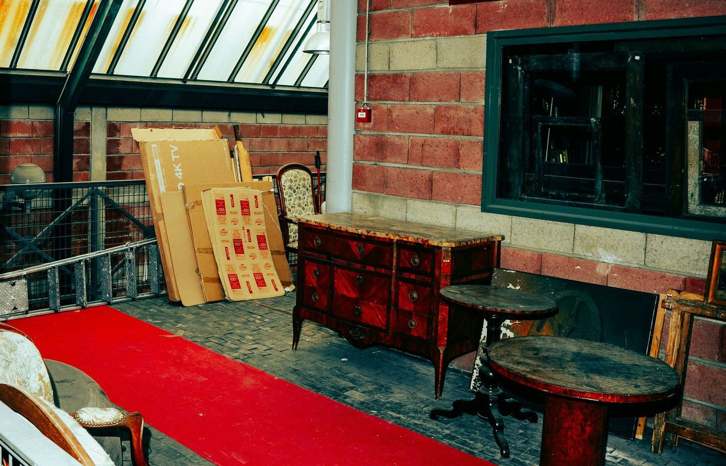 Red carpet leads to antique furniture display.